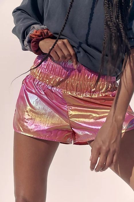 A photo of the model wearing the shorts in a pink iridescent color.