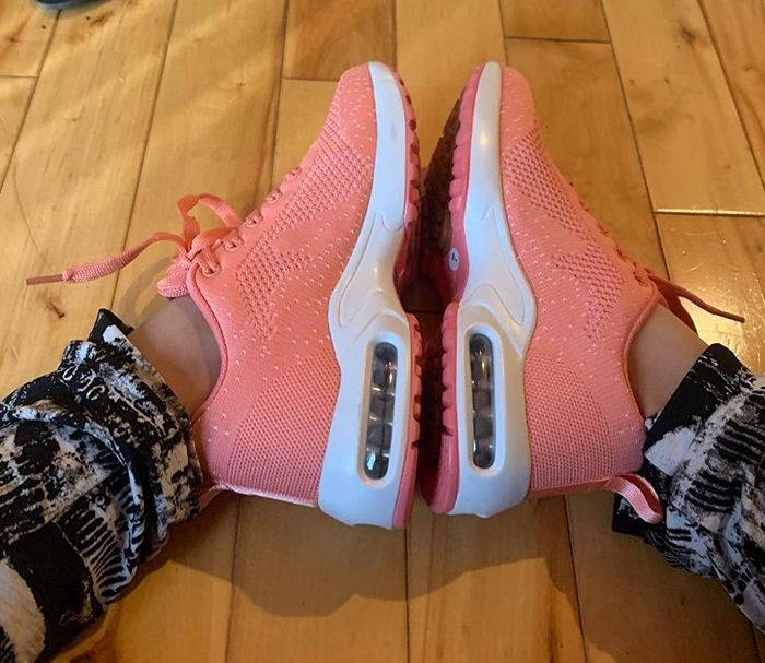 A reviewer wearing peach sneakers, showing off the gel accents with feet placed heel-to-heel for display