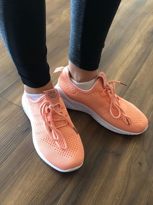 A reviewer showcasing pink ZYEN tennis shoes