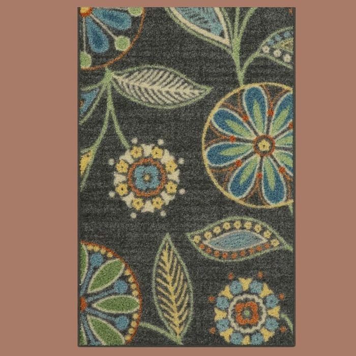 A beige rug with a black botanical design