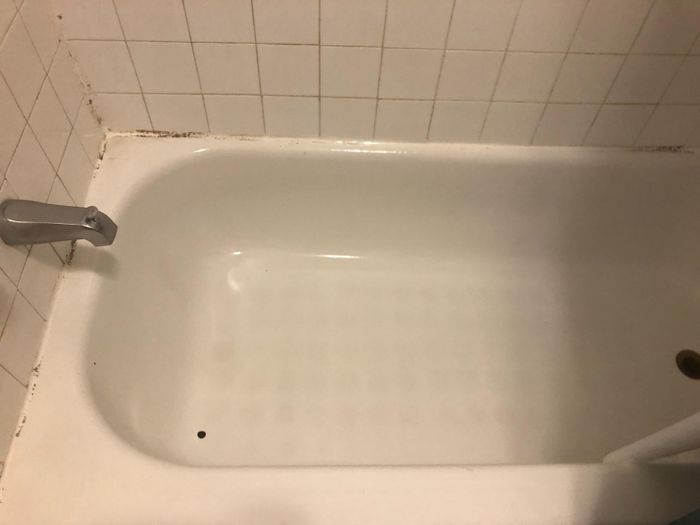 After image showing the same bathtub now sparkling clean and white