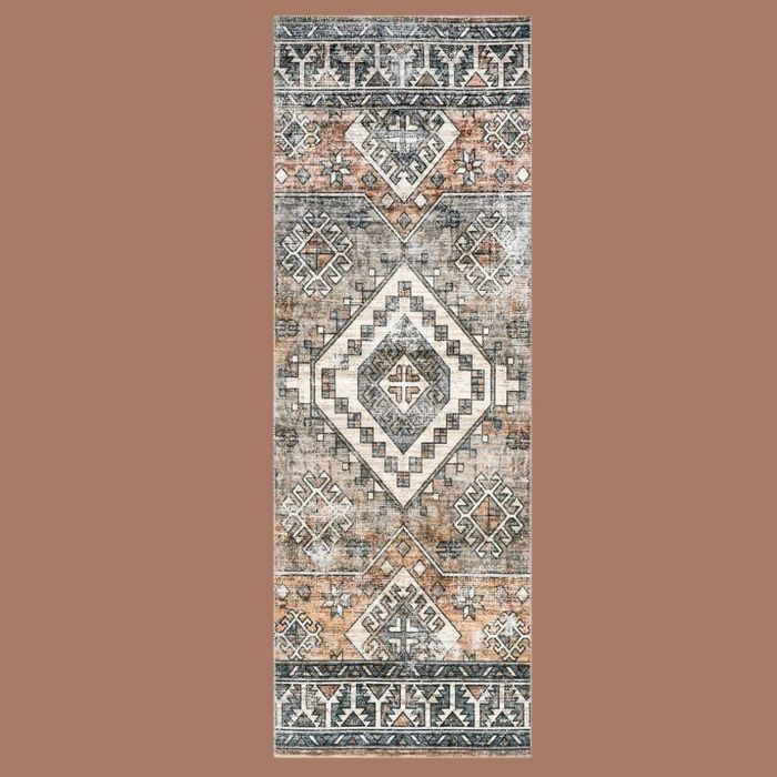 A rug with a vintage, faded pattern set against a beige backdrop