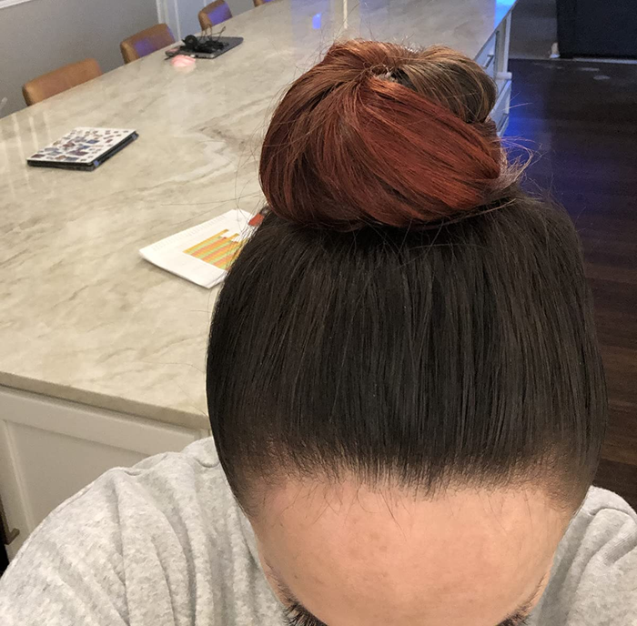 An image of a reviewer showcasing a top bun styled using corkscrew pins.