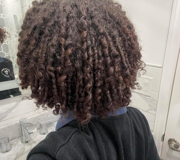 A person with curly hair, seen from the back