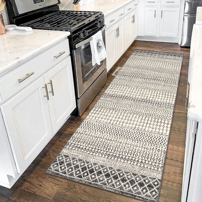 A diamond-patterned runner in neutral tones placed on a wooden kitchen floor