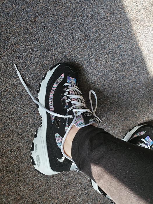 A reviewer wearing Skechers DLite sneakers