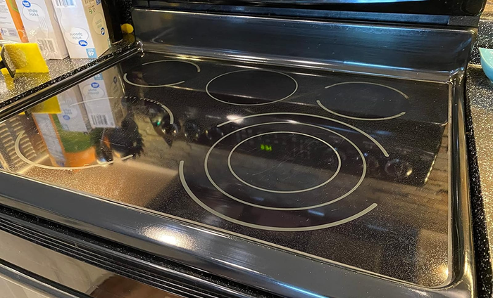 A reviewer's after image showing the same glass stovetop now spotless and clean.