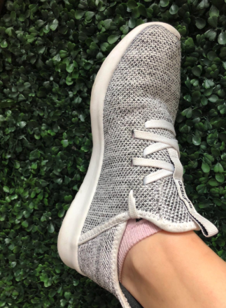 A reviewer showing the side view of Adidas Cloudfoam Pures