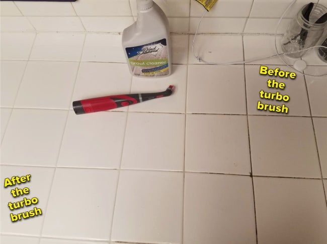 A brush rests on the floor, with one side of the tiled surface completely clean and white after use, while the right side still holds black grime in the tile’s crevices.