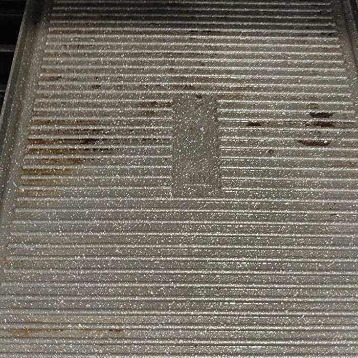 The baking sheet after the foam has been rinsed off, with most of the stains gone