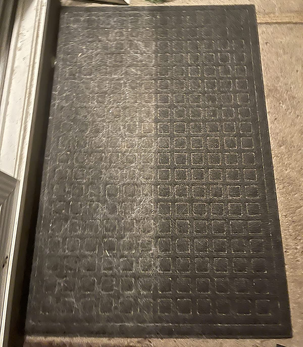 A before-and-after image from a reviewer: one side of the doormat is covered in pet hair, while the other side is spotless and free from hair.