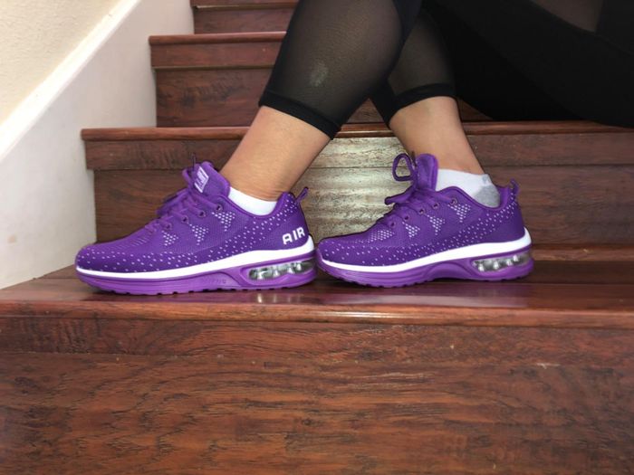 Reviewer showing a side profile of the purple STQ running sneakers