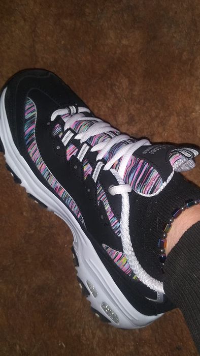 A reviewer wearing Skechers DLite running shoes