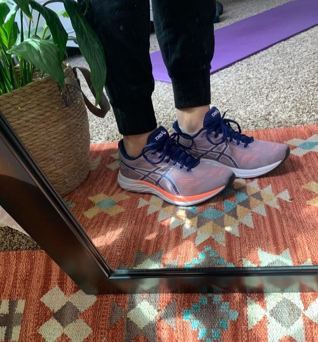 A reviewer wearing the multi-colored shoes with laces and a gel-cushioned heel