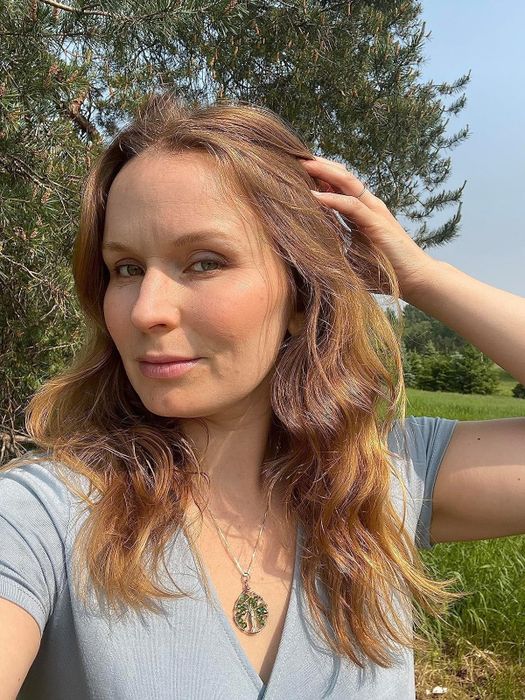A reviewer’s red hair cascades in waves
