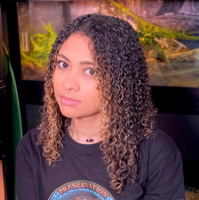A reviewer displaying glossy, tightly coiled ribbon-like curls.
