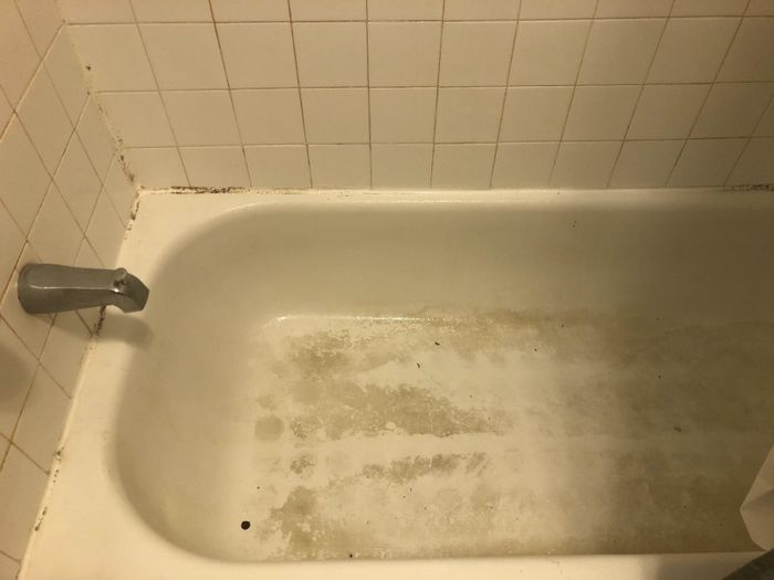 Reviewer before image showing a bathtub with visible dirt and stains
