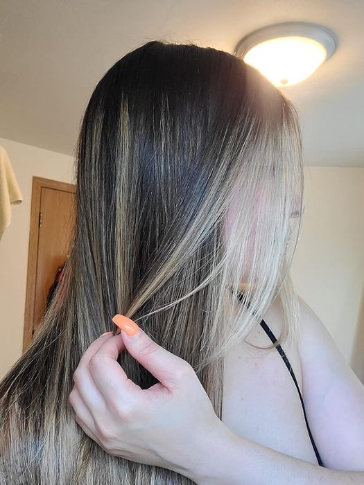 A reviewer with long, straight, shiny, and frizz-free hair