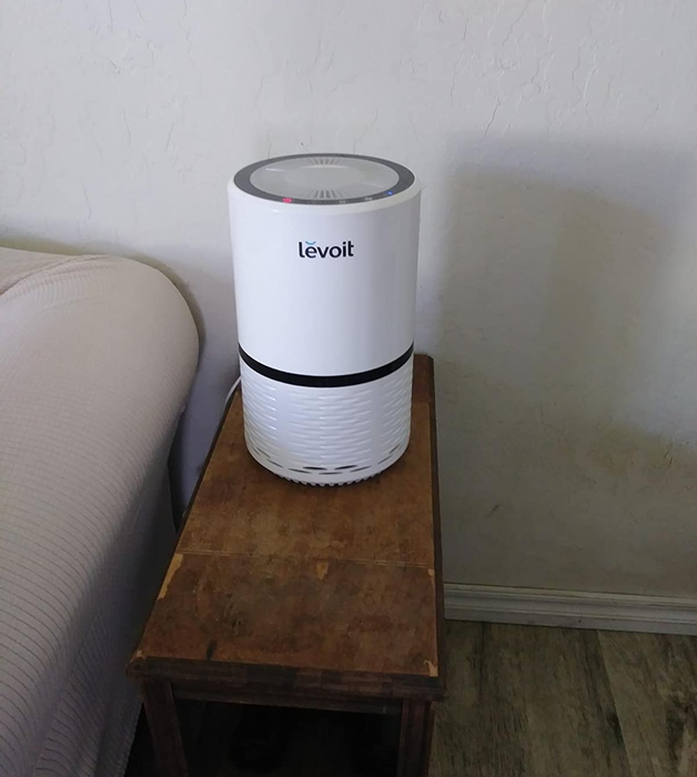 A review image showing the white Levoit air purifier placed on an accent table