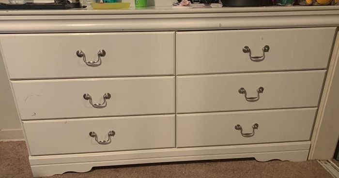 After cleaning with the pink paste, the same dresser shows nearly all the black marks gone, with only faint traces remaining that are hard to spot