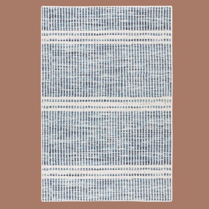 A blue and white patterned rug set against a beige background