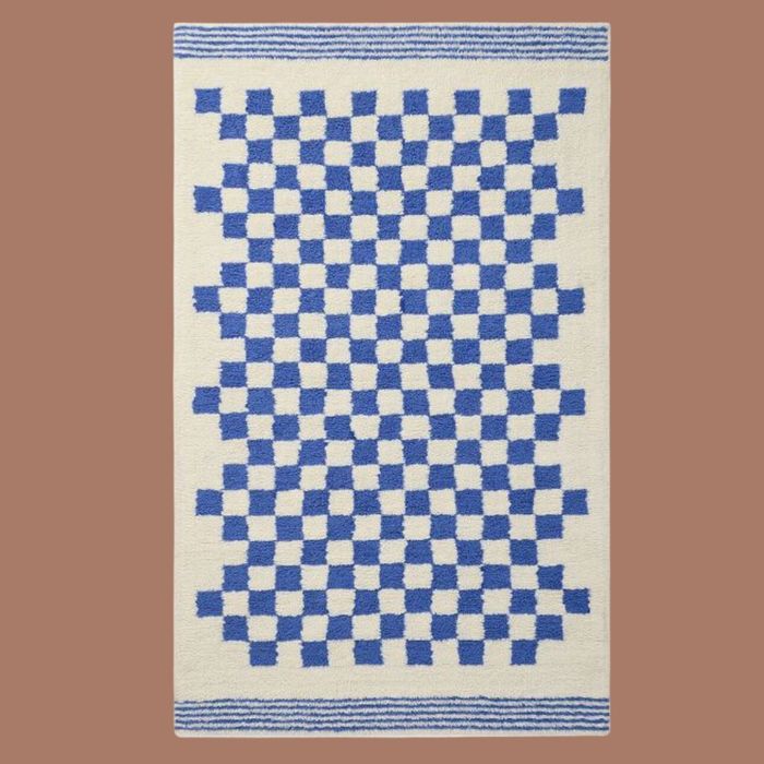 A blue and white checkered rug set against a beige background