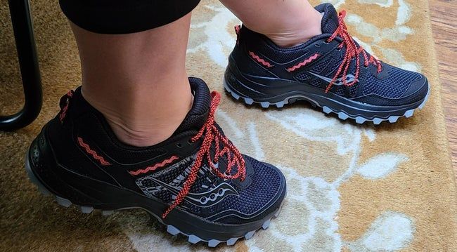 A reviewer wearing sturdy sneakers with laces and a textured sole that helps prevent slipping