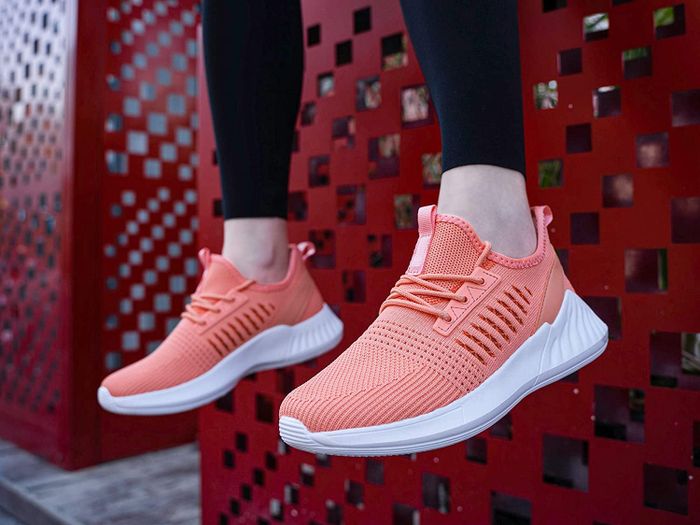 A model sitting and wearing peach SDolphin running shoes