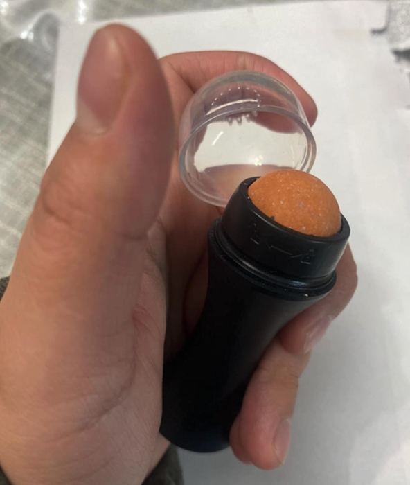 reviewer holding the roller with the cap off, showing the stone