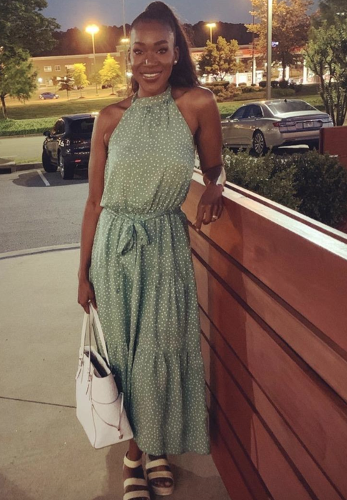 reviewer modeling a green dress with a stylish belt