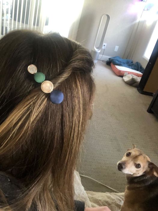 A reviewer sporting a blue, white, gold, and pink clip adorned with round stones