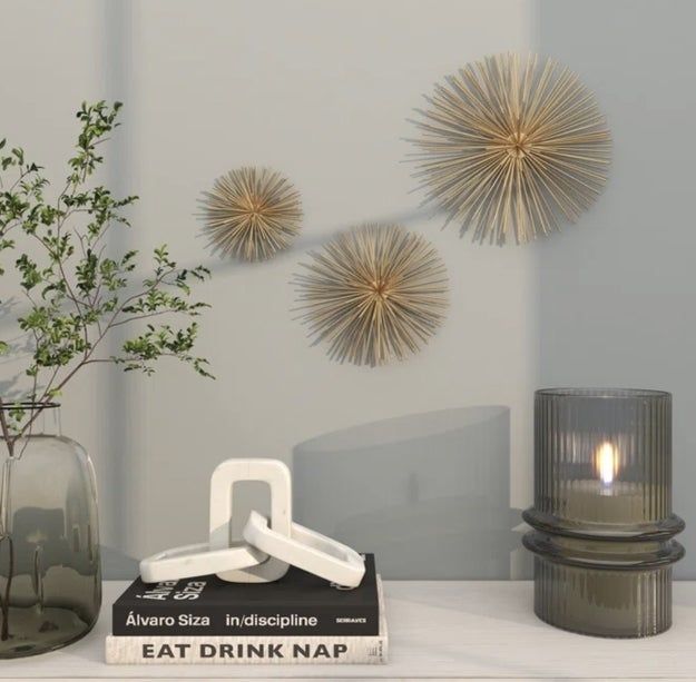 A table adorned with a candle, books, decorative items, and a plant, complemented by star-shaped wall decor