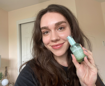 A person holds the serum bottle in their hand.