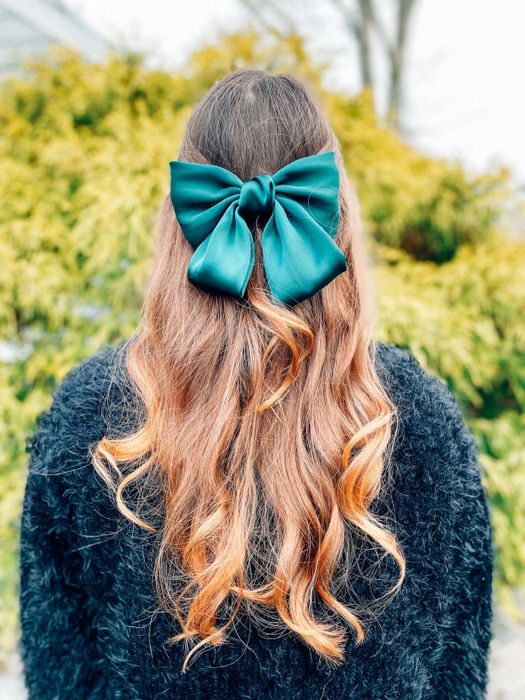 A photo of a reviewer’s hair from the back, highlighting a green bow