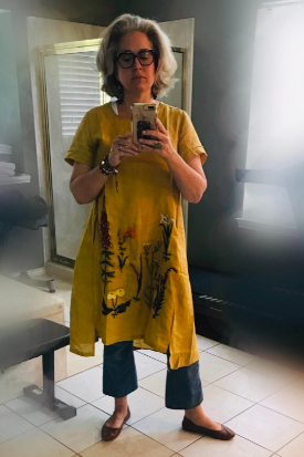 a short-sleeve yellow dress featuring embroidered flowers, styled by the reviewer with flared jeans and flats