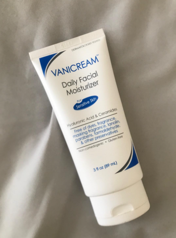 A bottle of Vanicream resting on a bed.