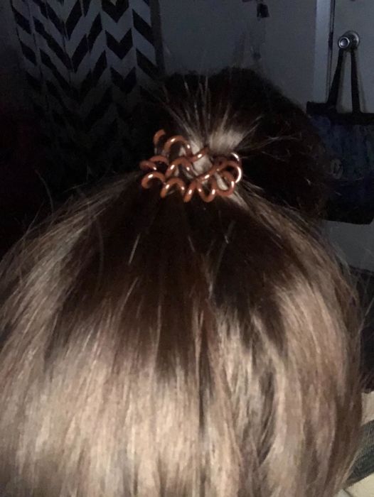 A reviewer with the brown version holding their hair in a ponytail