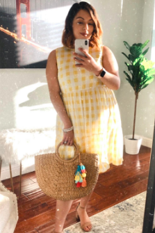 reviewer showcasing a sleeveless, knee-length yellow checkered dress