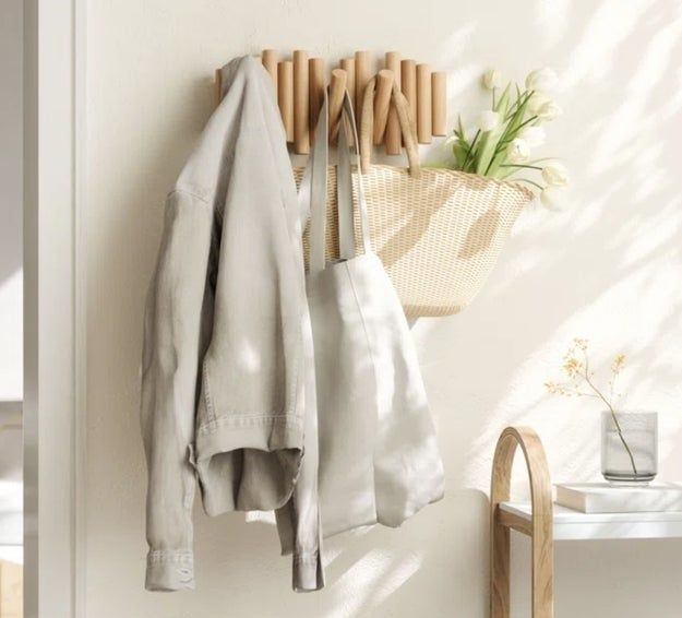 A wall-mounted hook displaying a jacket and tote bag