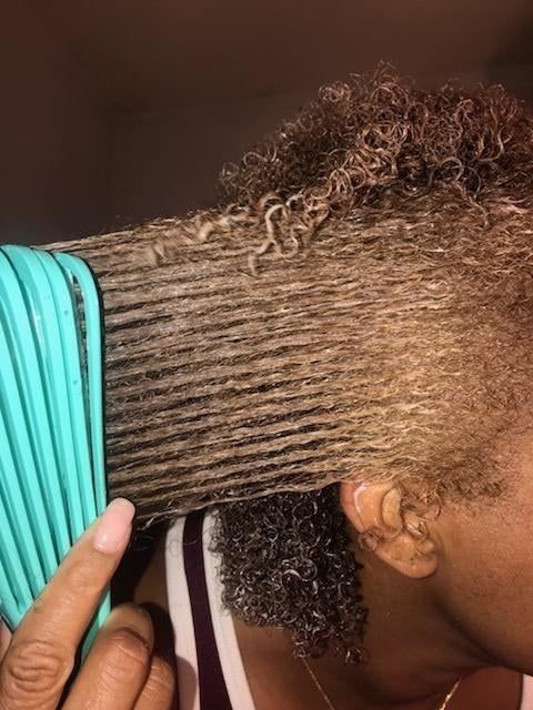 the same reviewer effortlessly brushing through their hair using the detangling brush