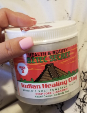 Reviewer holding a tub of the mask