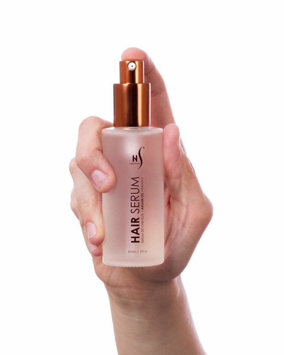 a hand holding a compact spray bottle