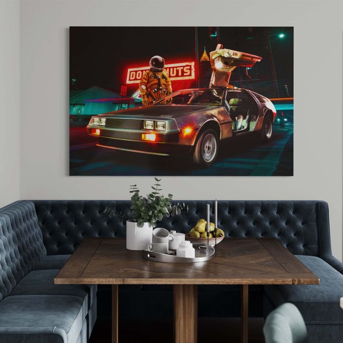 A wall art piece featuring a DeLorean car under neon lights with a figure holding a boombox, displayed above a couch
