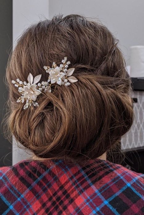 A reviewer wearing the large jeweled and beaded flower pins in an updo