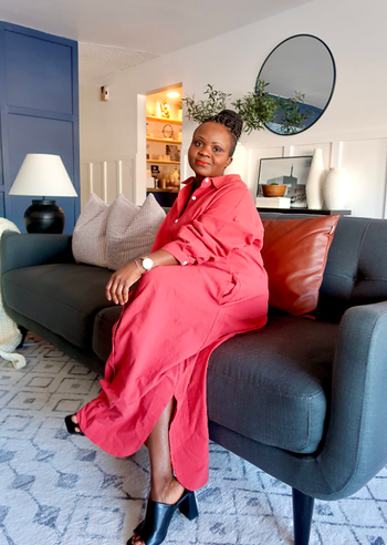 reviewer lounging on a sofa at home, wearing the shirt dress