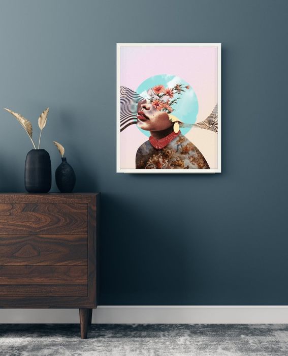 An abstract art piece featuring a surreal collage of a woman and natural elements, hung above a wooden cabinet with a vase