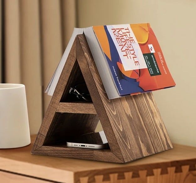 A book holder placed on a table, supporting an open book
