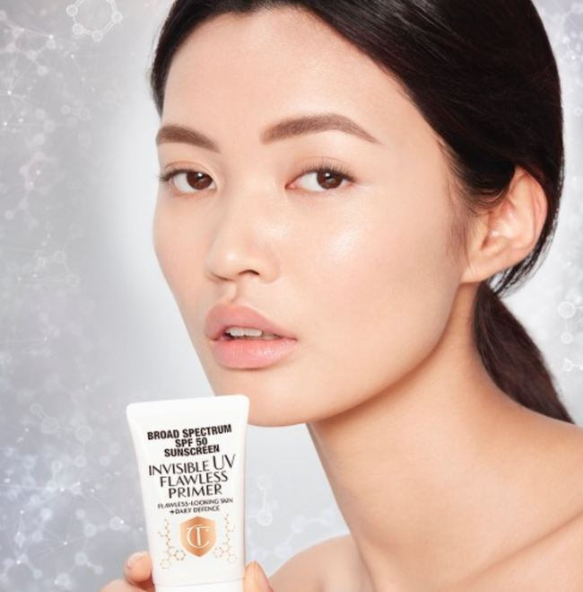 Model holding the bottle of Invisible UV Flawless Primer.
