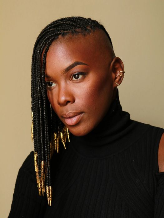 A model showcasing gold loc beads woven into their hair
