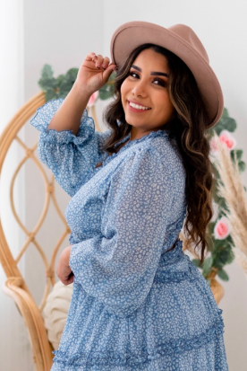 Curvy reviewer wearing the dress paired with a stylish tan hat